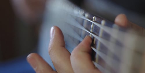 Close Up Playing White and Black Bass Guitar