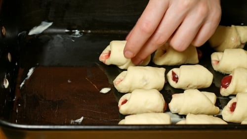 Baker Puts Croissants On The Baking Tray Pan