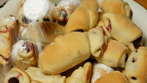 Sprinkling Cooked Croissants With Powdered Sugar