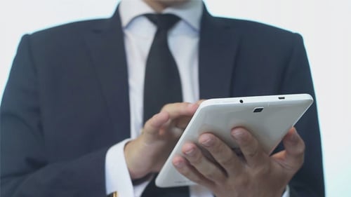 Person in Suit Using Tablet Close Up
