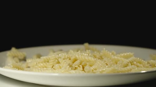 Cooked Rotini Pasta Falling on Plate