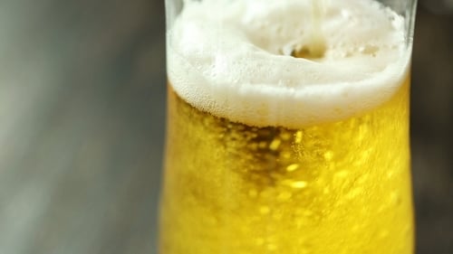 Golden Beer Poured into Glass with White Foam