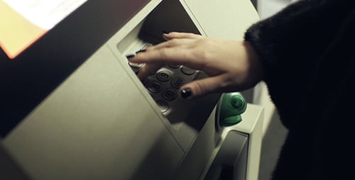 Woman Using ATM Machine at Night