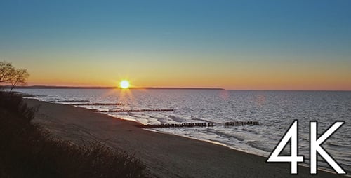 Picturesque Sunrise at Beach with Wooden Breakwaters
