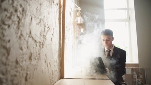 Homme utilisant une cigarette électronique personnelle avancée et une tablette usagée
