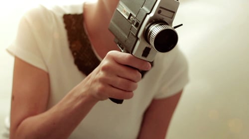 Woman Uses a Vintage Camera Indoors