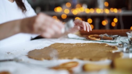 Woman Cutting Gingerbread Cookies for the Holidays