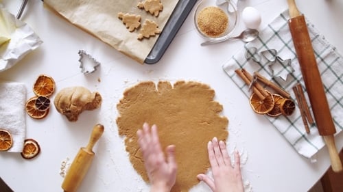 Hands Cutting Christmas Cookies for Holiday Celebration