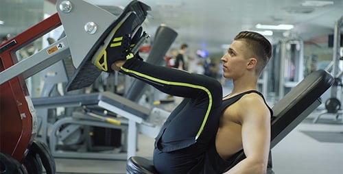 Young Adult Does Leg Presses at Gym