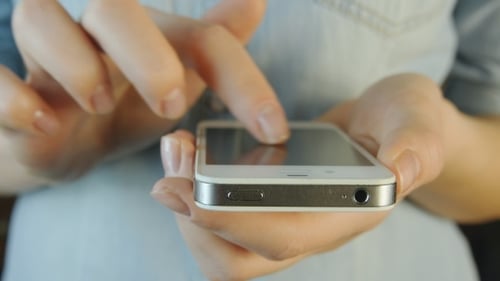 Woman's Hands Tapping on Smartphone Screen Close Up