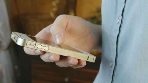 Hand Interacting with Gold Smartphone