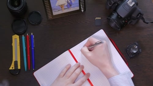 Un hombre escribe una sonrisa con un bolígrafo en el cuaderno