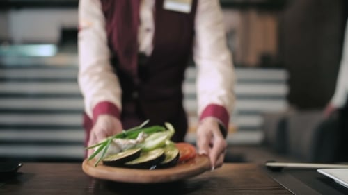 Waiter Delivers Vegetarian Dish For Grilling