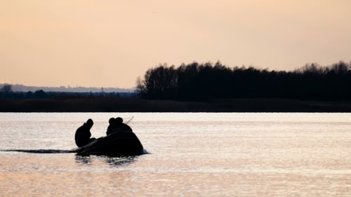 Figures in Boat on Lake at Sunset