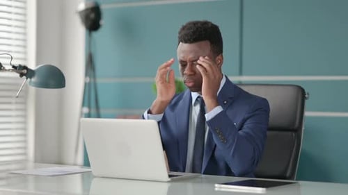Executive experiencing headache while working at computer