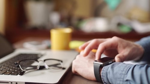 Website-Designer, der mit Smartwatch und digitalem Tablet arbeitet.