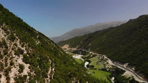 Aerial Drone Footage View Flight Over Mountain with Forests Fields and River