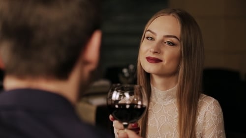 Young Happy Couple On Romantic Date Drinking Glass Of Red Wine
