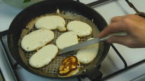 Pancakes Being Flipped in a Frying Pan