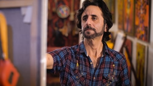 Portrait Of Male Artist Working On Painting In Studio