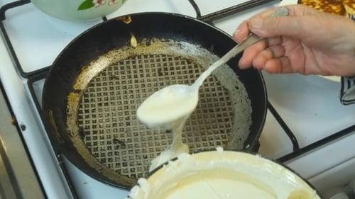 Grandmother Fries Pancakes In a Frying Pan
