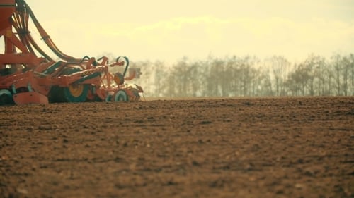 Tractor Plowing Field At Sunset