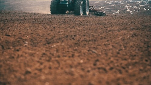 Tractor Plowing Field At Sunset