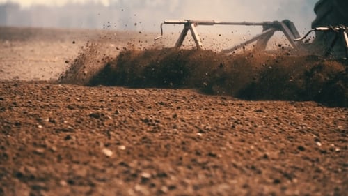 Tractor Plowing Field At Sunset