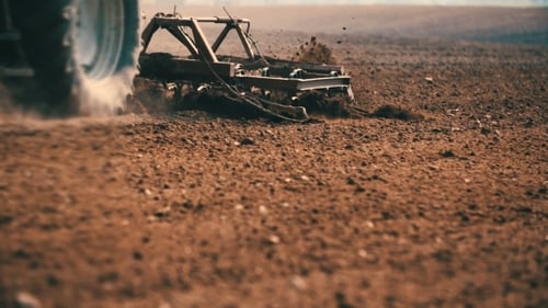 Tractor Plowing Field At Sunset