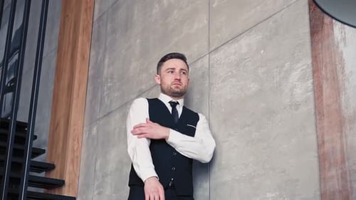 Man Leaning Against Wall, Contemplating Indoors