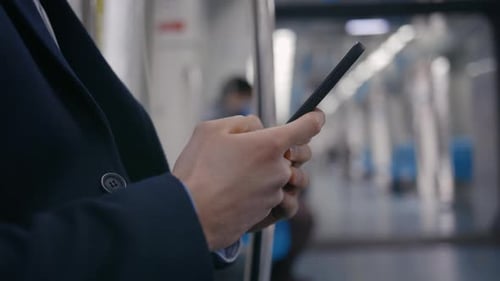 Young Man Using Smartphone While Moving in Metro