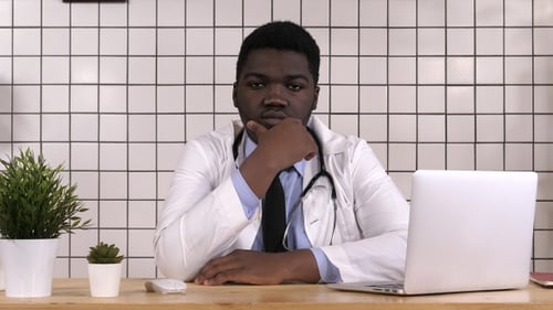 African American doctor looking serious to camera thinking