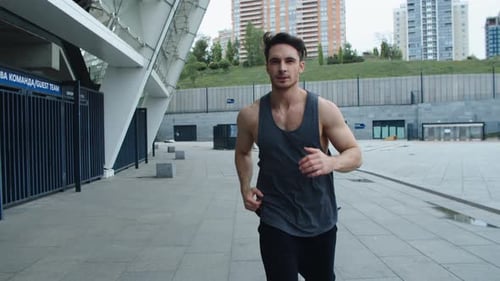 Sportsman Running at Cardio Training Outdoor. Front View of Athlete Man Jogging