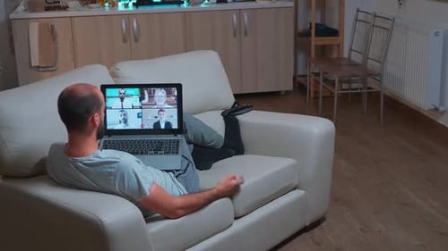 Man Attends Virtual Meeting from Home on Laptop