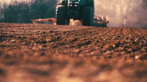 Tractor Plowing Field At Sunset