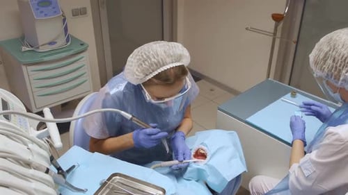 Dentist Performing Dental Procedure in a Hospital Room