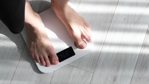 Man Steps on Digital Scale for Weight Measurement