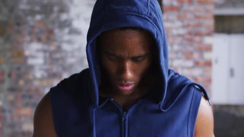 Intense Man Wearing Hoodie Stares at Camera