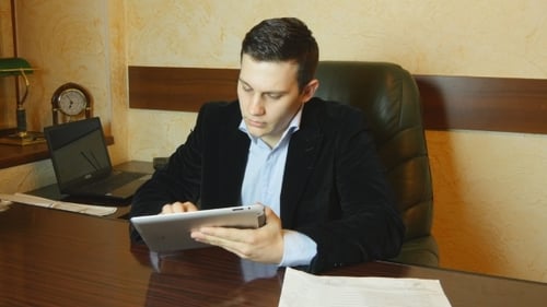 Young Businessman Working On Tablet Computer In Office