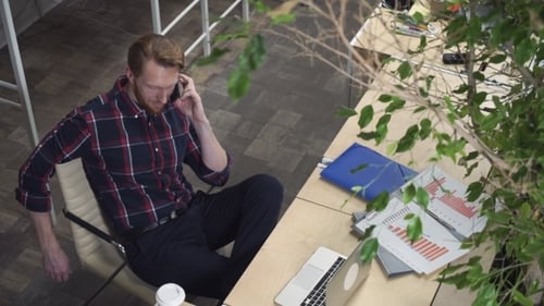Man on Cell Phone at Desk in Office