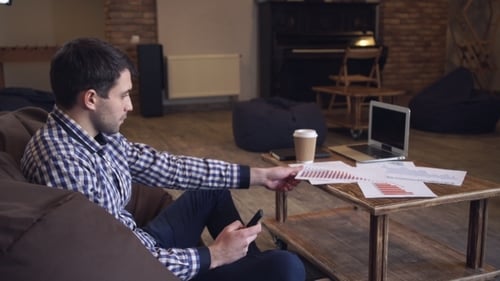 Man Analyzing Data on Mobile Phone in Office
