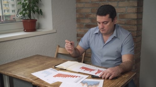 The Manager Checks The Sales Data For The Month, Are On The Table The Documents.
