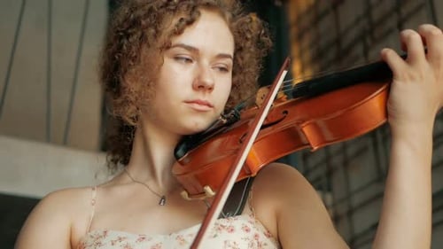 Woman with Curls Plays the Violin Artistically