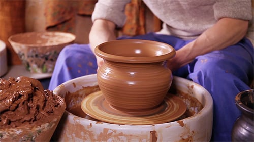 Potter Shaping Clay Pot on Wheel