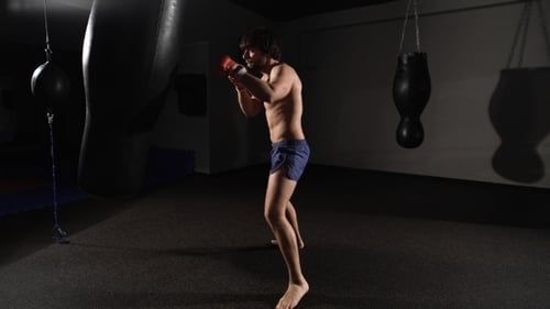 Fureur. Beau combattant musclé donnant un puissant coup de pied en avant