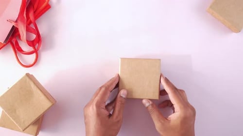 Hands Place Small Birthday Gift Overhead