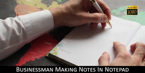 Businessman Making Notes In Notepad