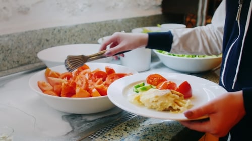 Putting Tomatoes In a Plate In a Cafe With Self-Service