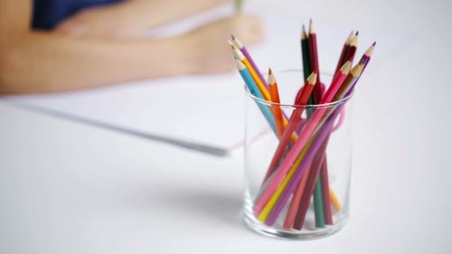 Child Drawing With Colored Pencils at Table