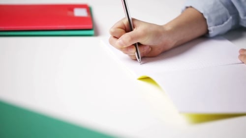 School Girl Hand Writing Math Task To Notepad